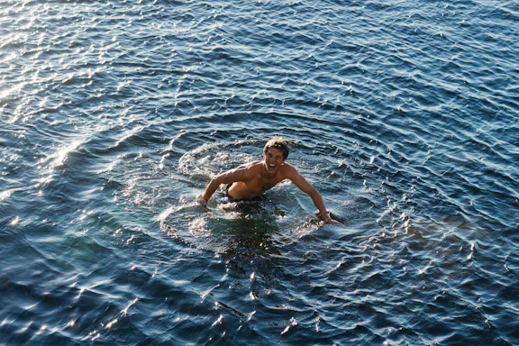 A joyful swimmer reaching out to connect with the CNCA swimming club.