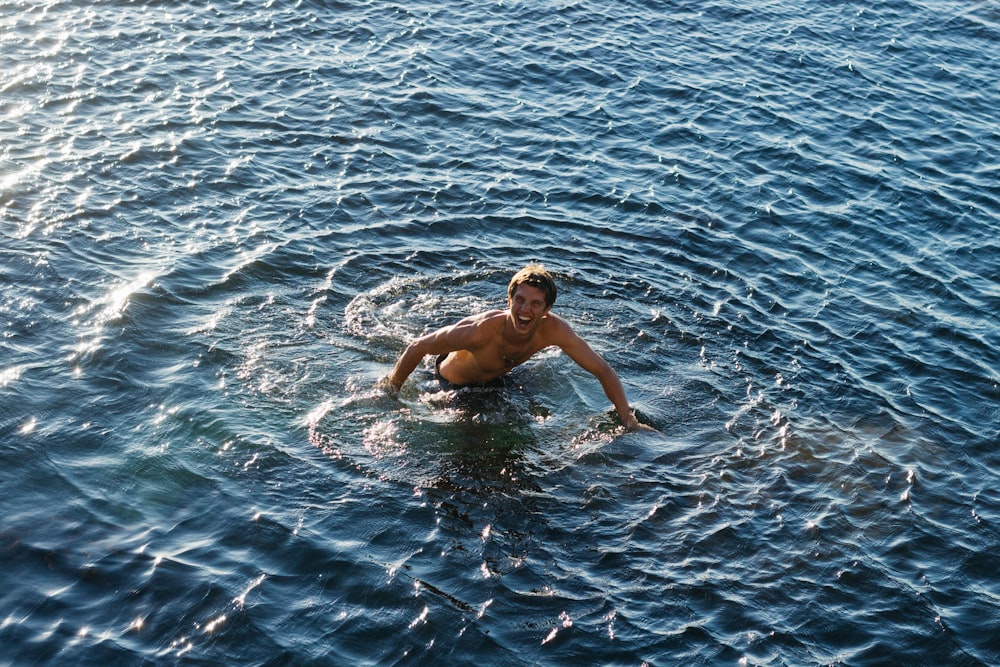 Oben-ohne-Mann schwimmt im Gewässer