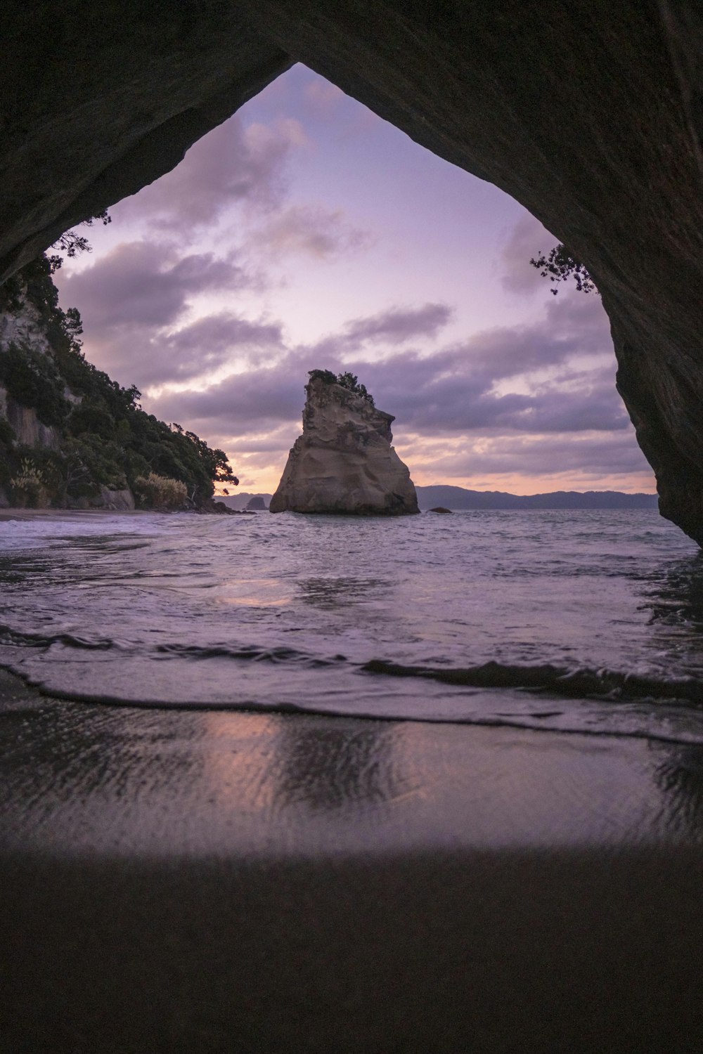 brown cave in front of shoreline