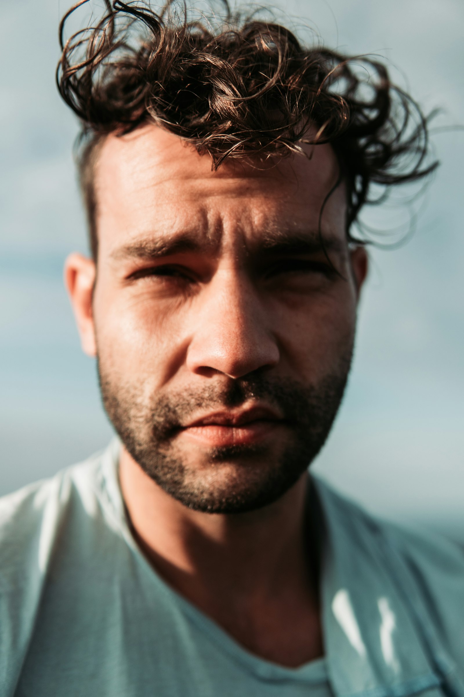 Man with tousled, textured wavy hair in natural light