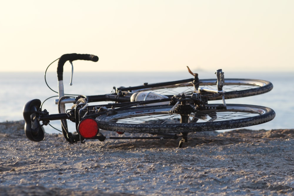 black commuter bike lying on shore
