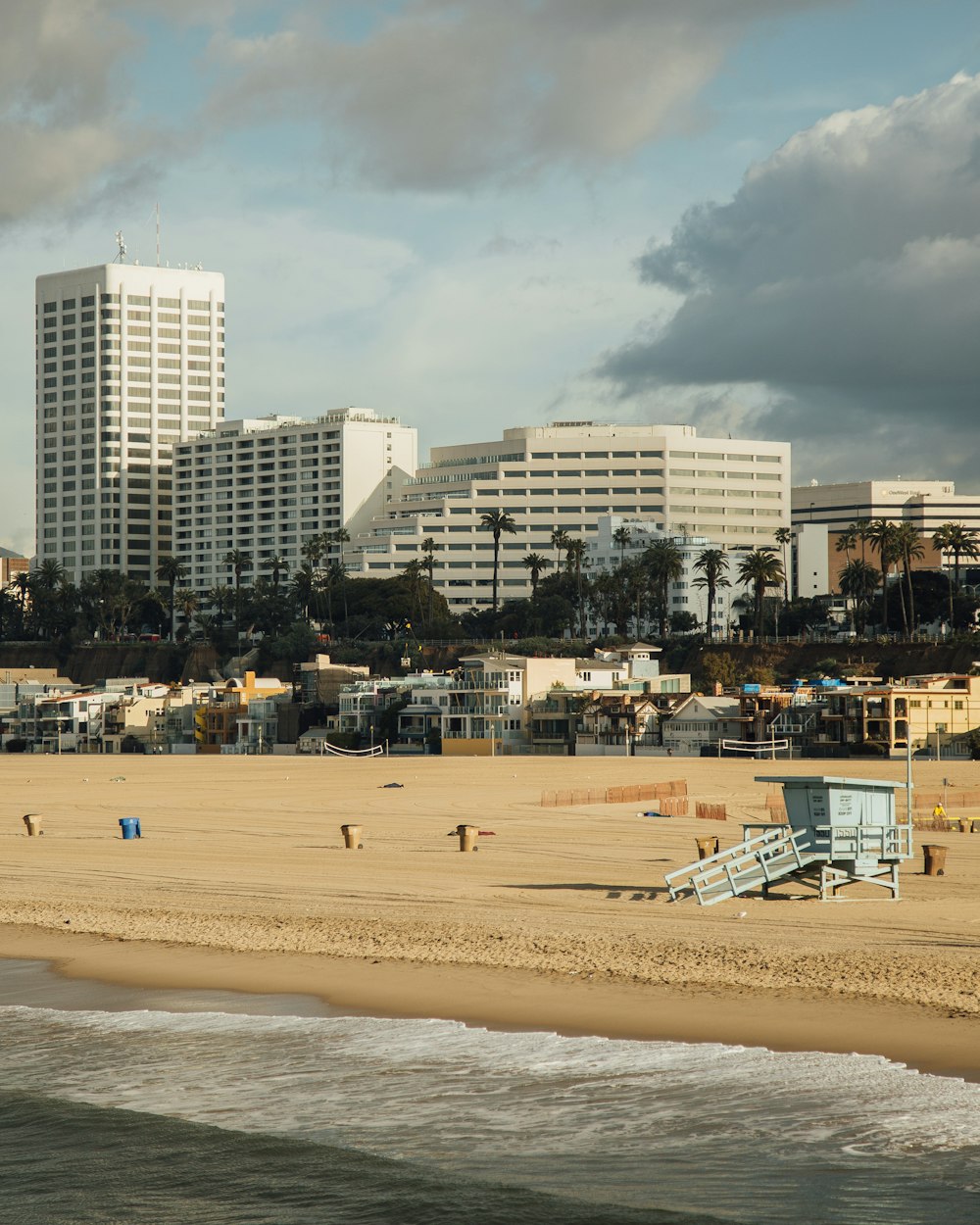 a beach with a few people on it and buildings in the background