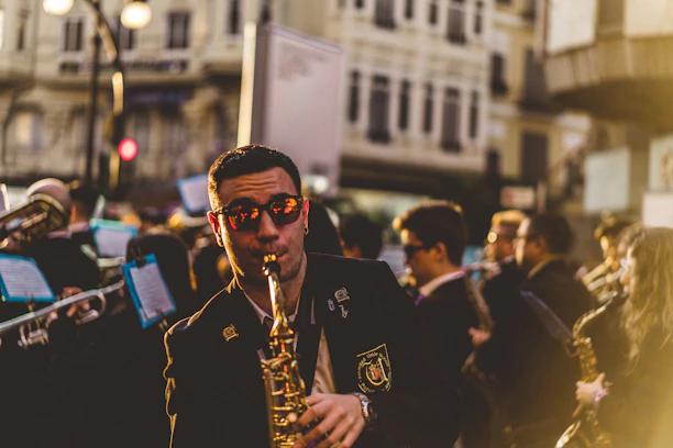A lively street musician playing saxophone in a bustling New York City park.