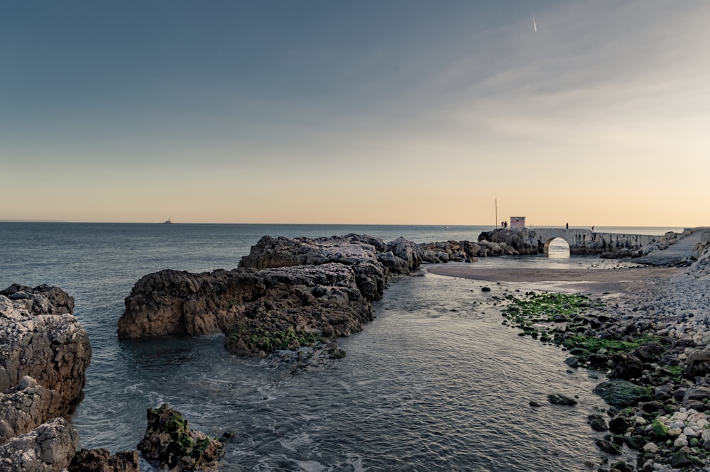 body of water near cliffs during daytime