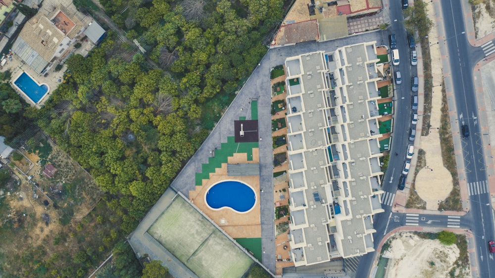 Photographie aérienne d’un bâtiment entre la piscine et la route pendant la journée