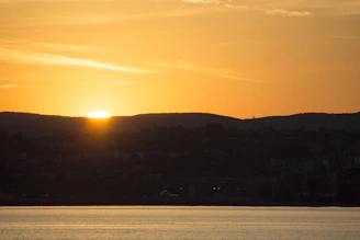 Sunset over the serene countryside of Palencia with rolling hills and a winding river.