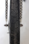 A close-up view of a bicycle tire featuring a detailed tread pattern that includes star shapes. The background is blurred, drawing attention to the tire's texture and structure.