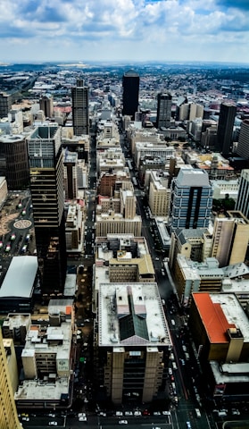 A drone's eye view of a bustling cityscape with skyscrapers and busy streets below.