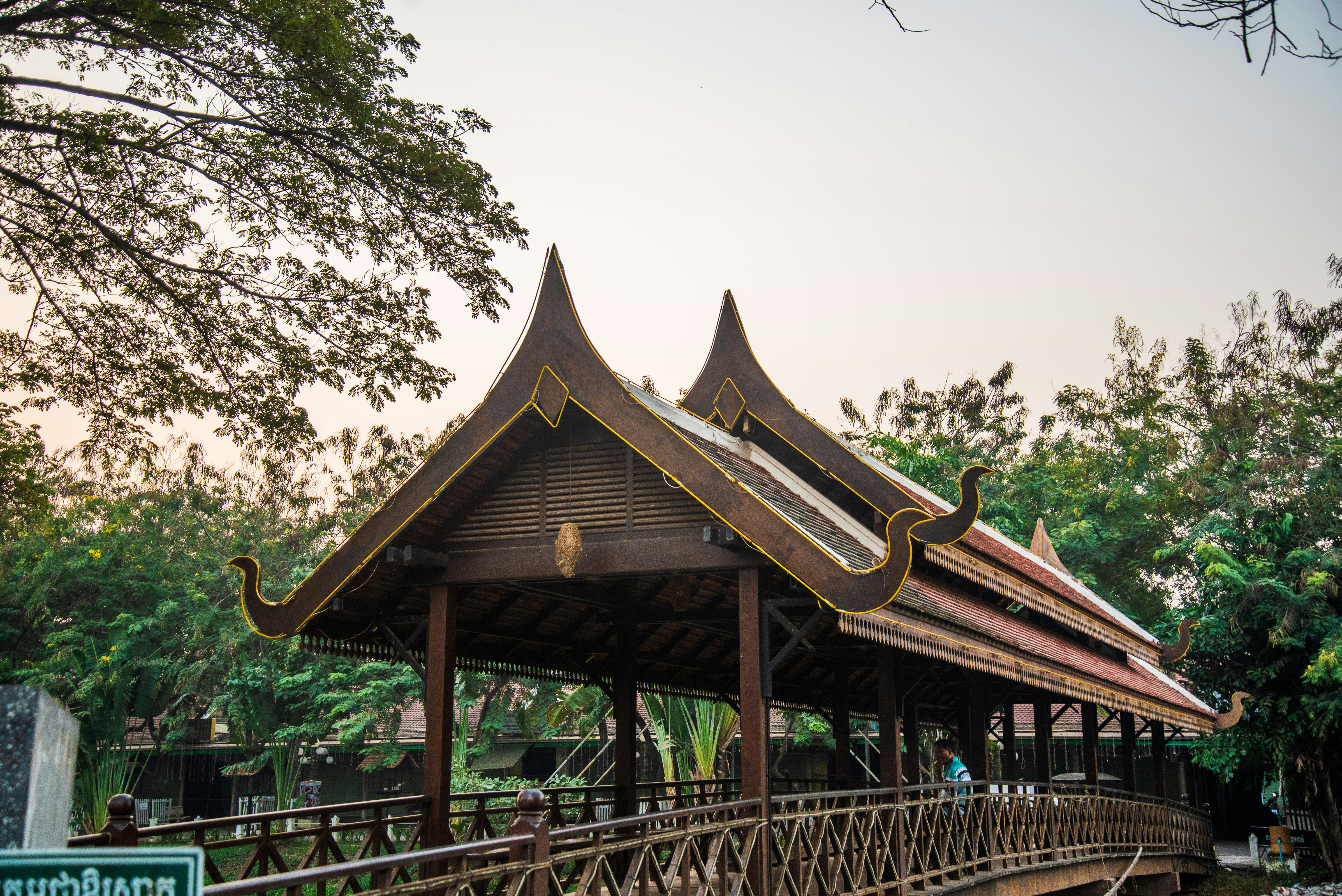 man leaning on brown barrier, 