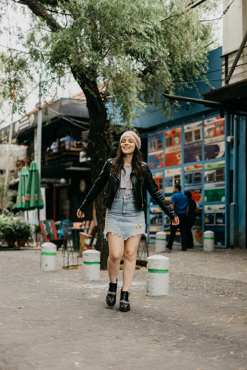 woman wearing black leather jacket standing near tree