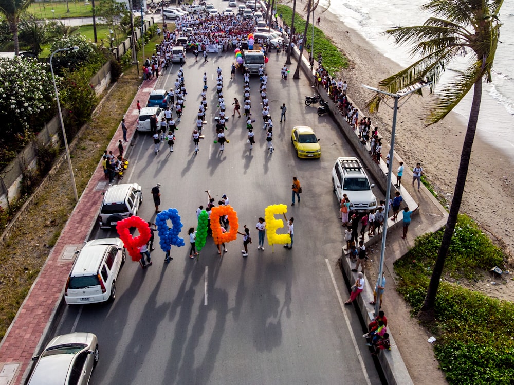 grupo de personas que caminan por la carretera llevando globos del Orgullo