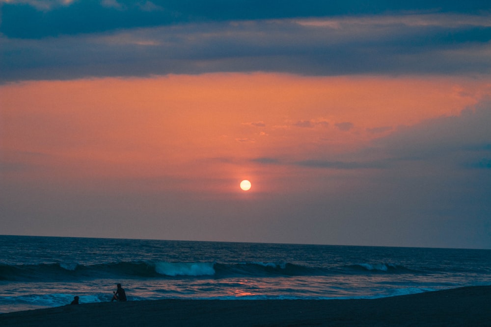 person on shore during golden hour