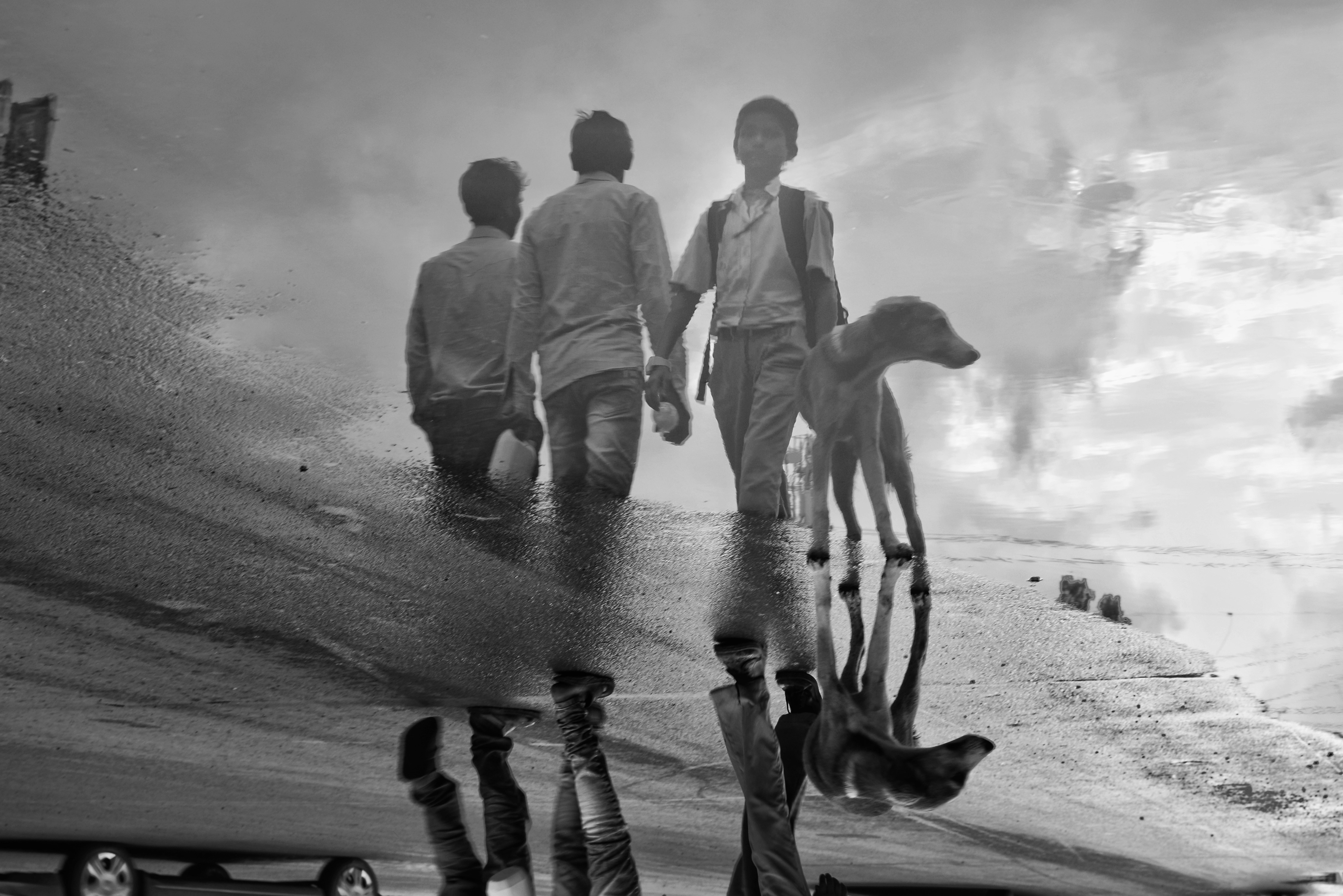 three men reflected on body of water beside door