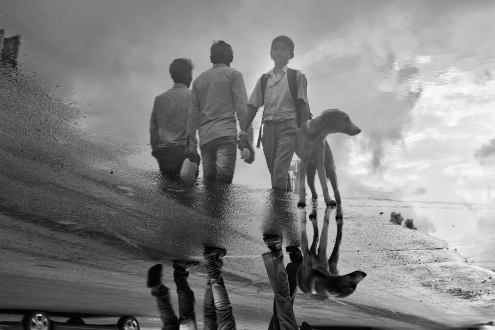 three men reflected on body of water beside door