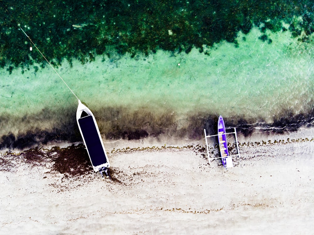 aerial photography of two boats on seashore