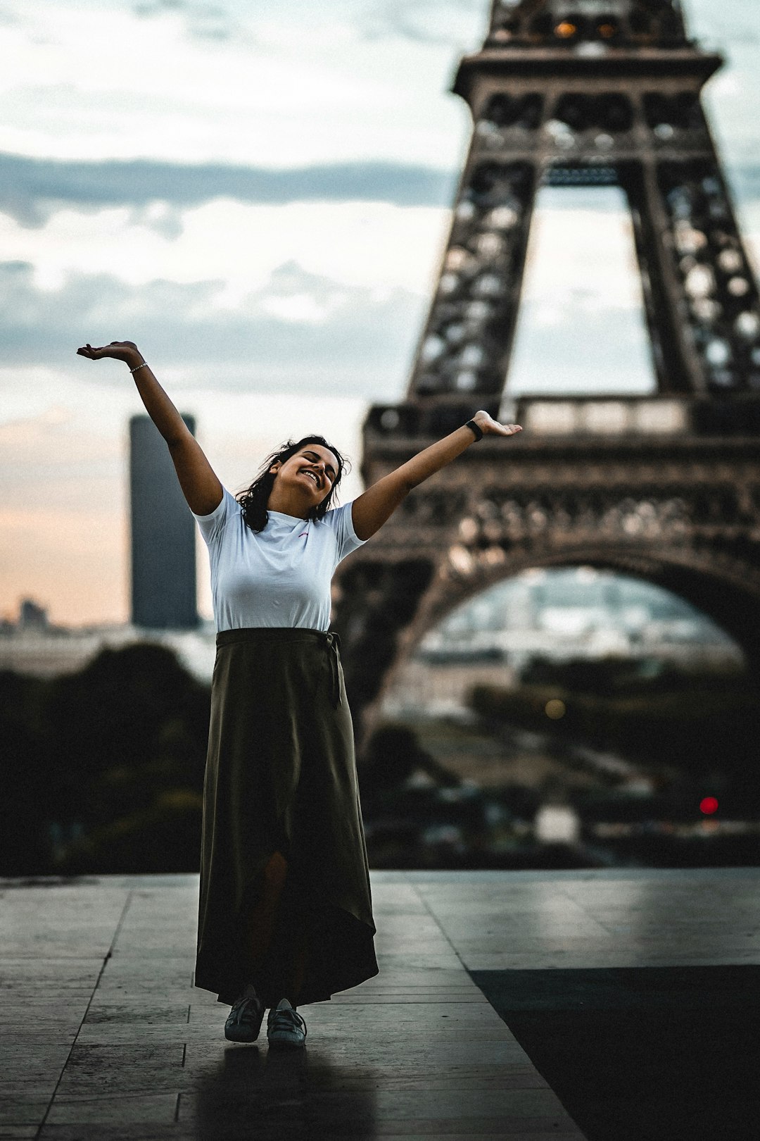 woman raising his two arms in front of Eiffel tower