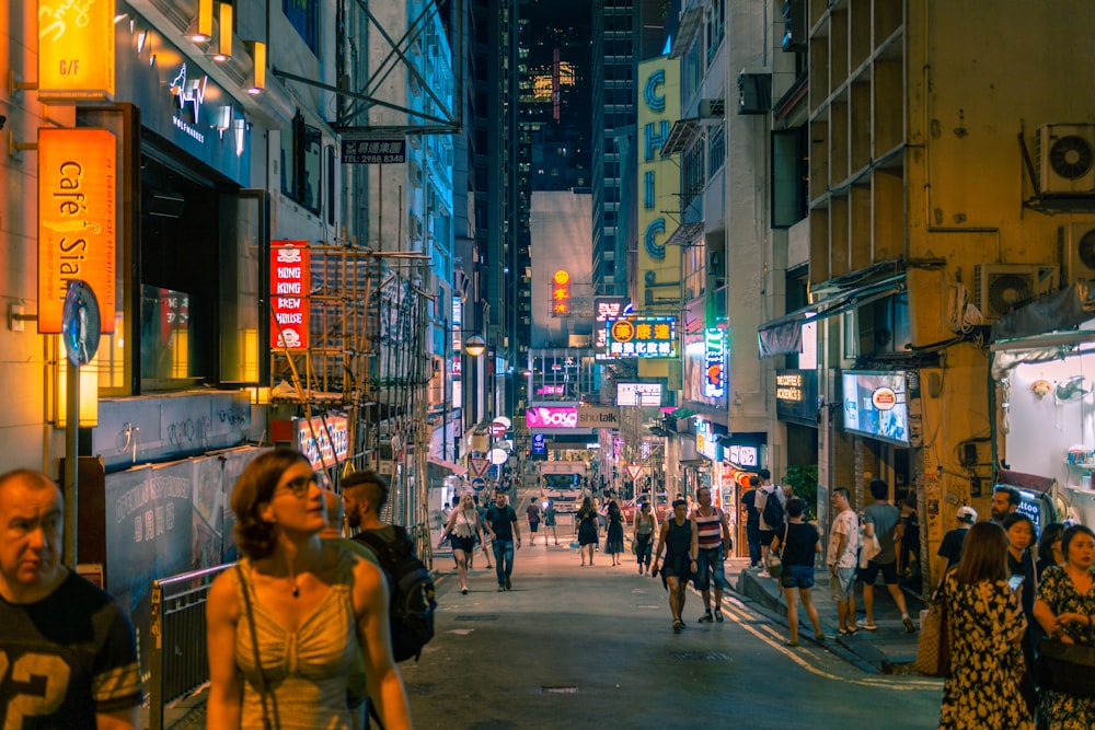 people walking along city road during nighttime