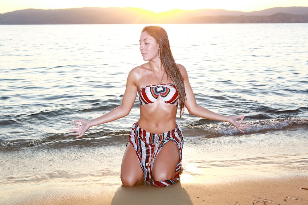 woman kneeling on the seashore photography