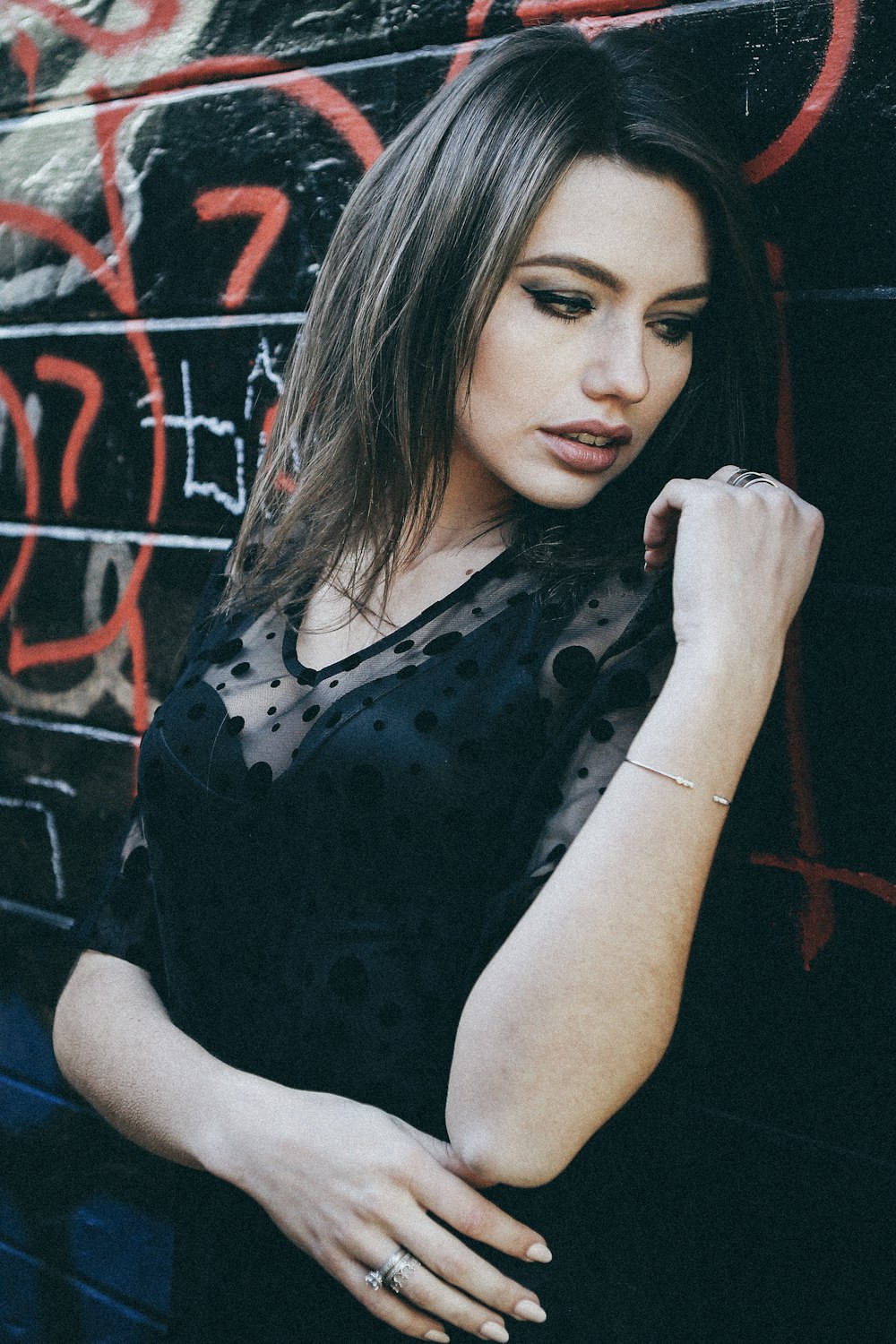 woman leaning on black wall