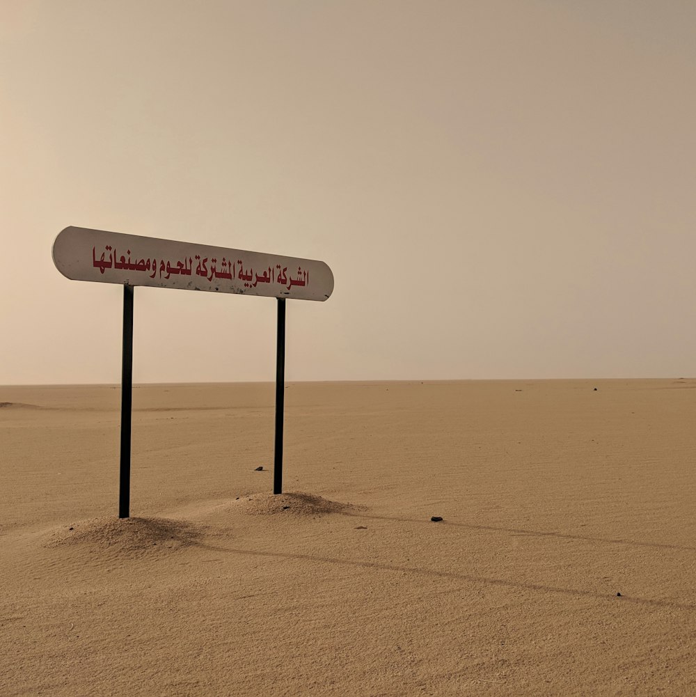 white wooden signage on the desert