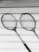 two gray badminton rackets on white wooden surface