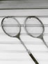 two gray badminton rackets on white wooden surface