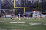 Young athletes practicing drills together on a sunny Michigan field.