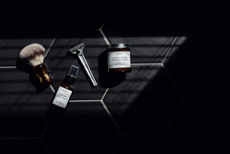 Luxurious shaving tools laid out on a charcoal countertop with silver accents.