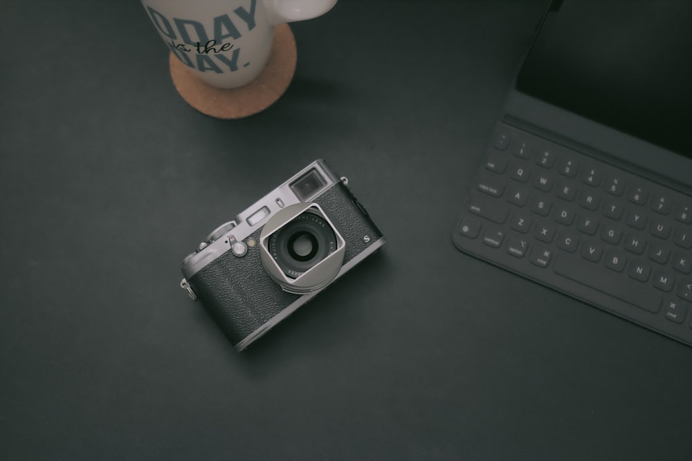 black-and-gray camera on table near tablet keyboard case