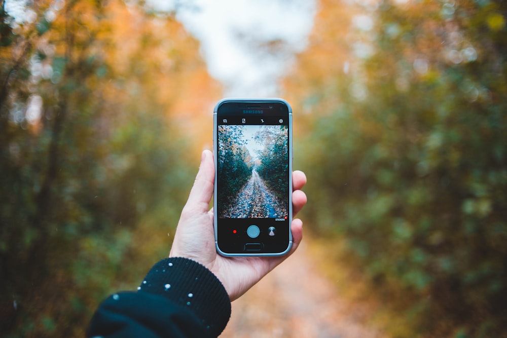 person holding black Samsung Android smartphone with camera application turned-on