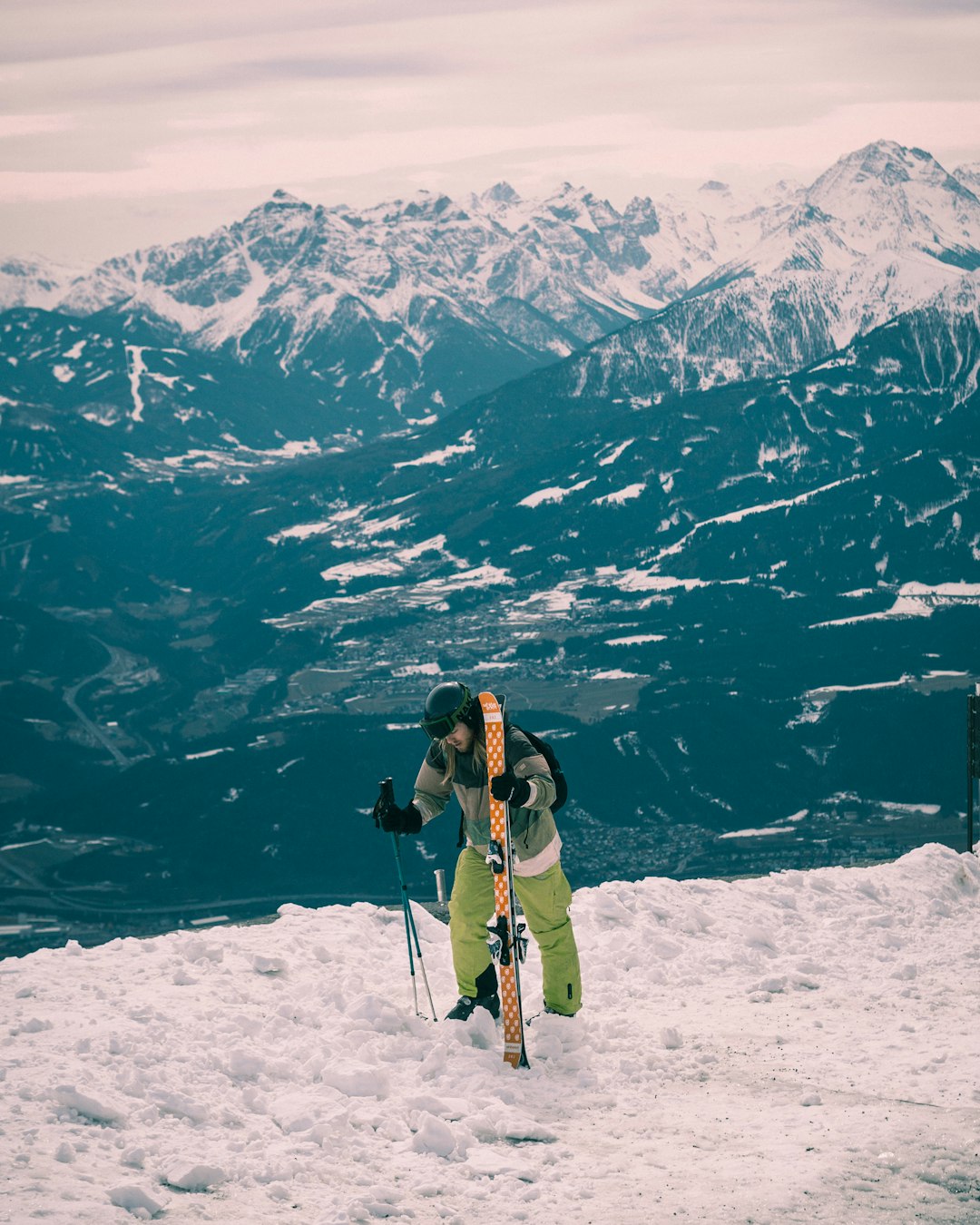 man holding skis standing on snow covered field