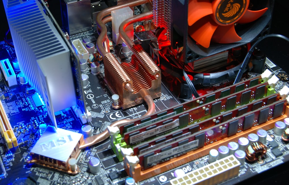 computer motherboard with RAM sticks and aftermarket cooling system