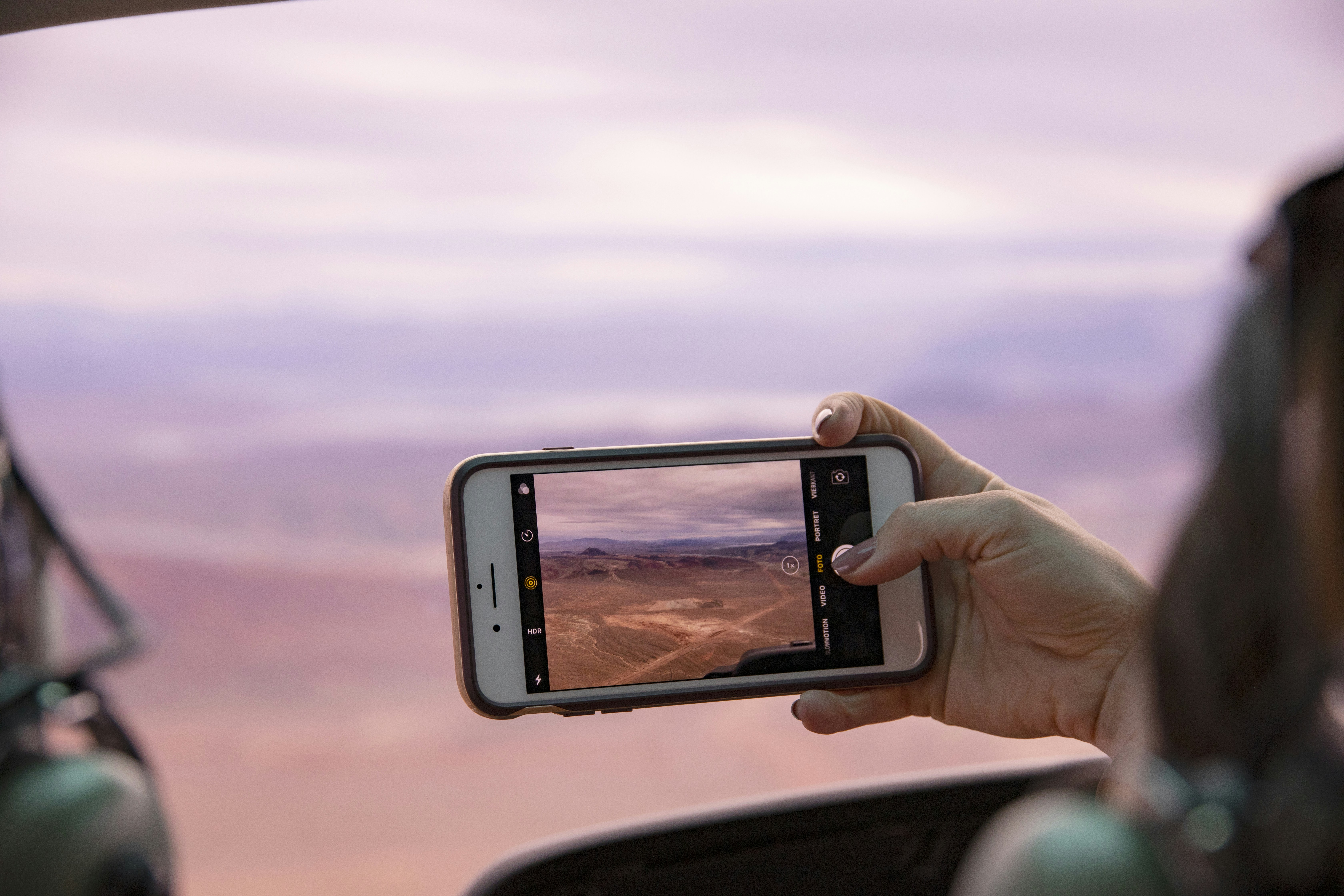 person taking photo of brown field