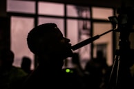 A silhouette of a speaker presenting to an engaged audience.
