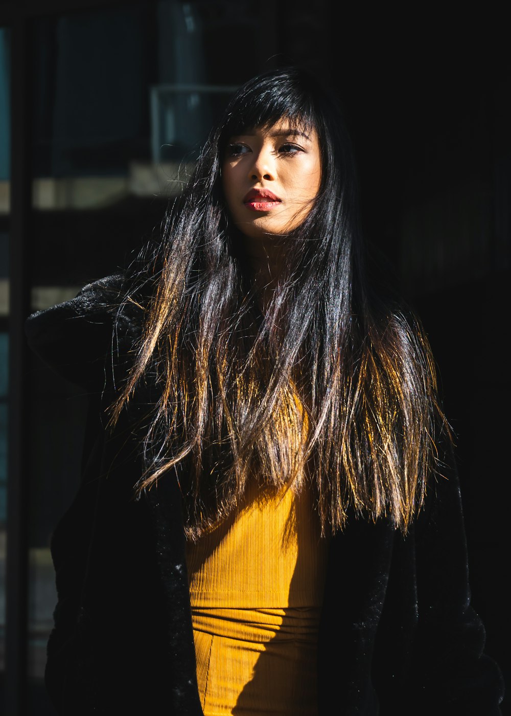 mulher no top amarelo e blazer preto