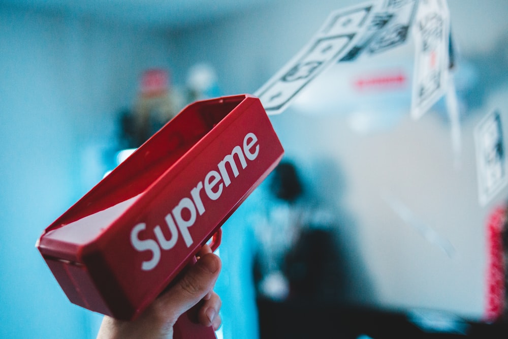 Person holding red Supreme bag photo – Free Human Image on Unsplash