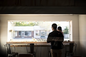 man carrying child looking through window during daytime