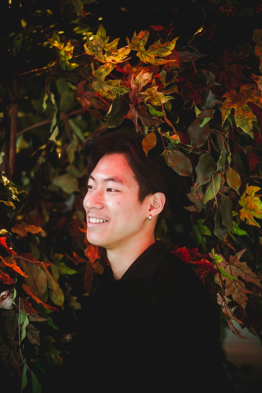 smiling man standing beside tree