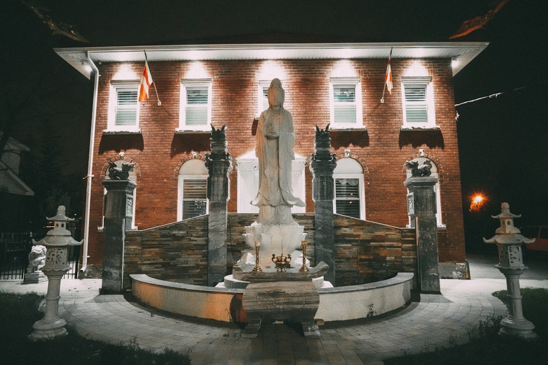 white statue in front of brown building during nighttime