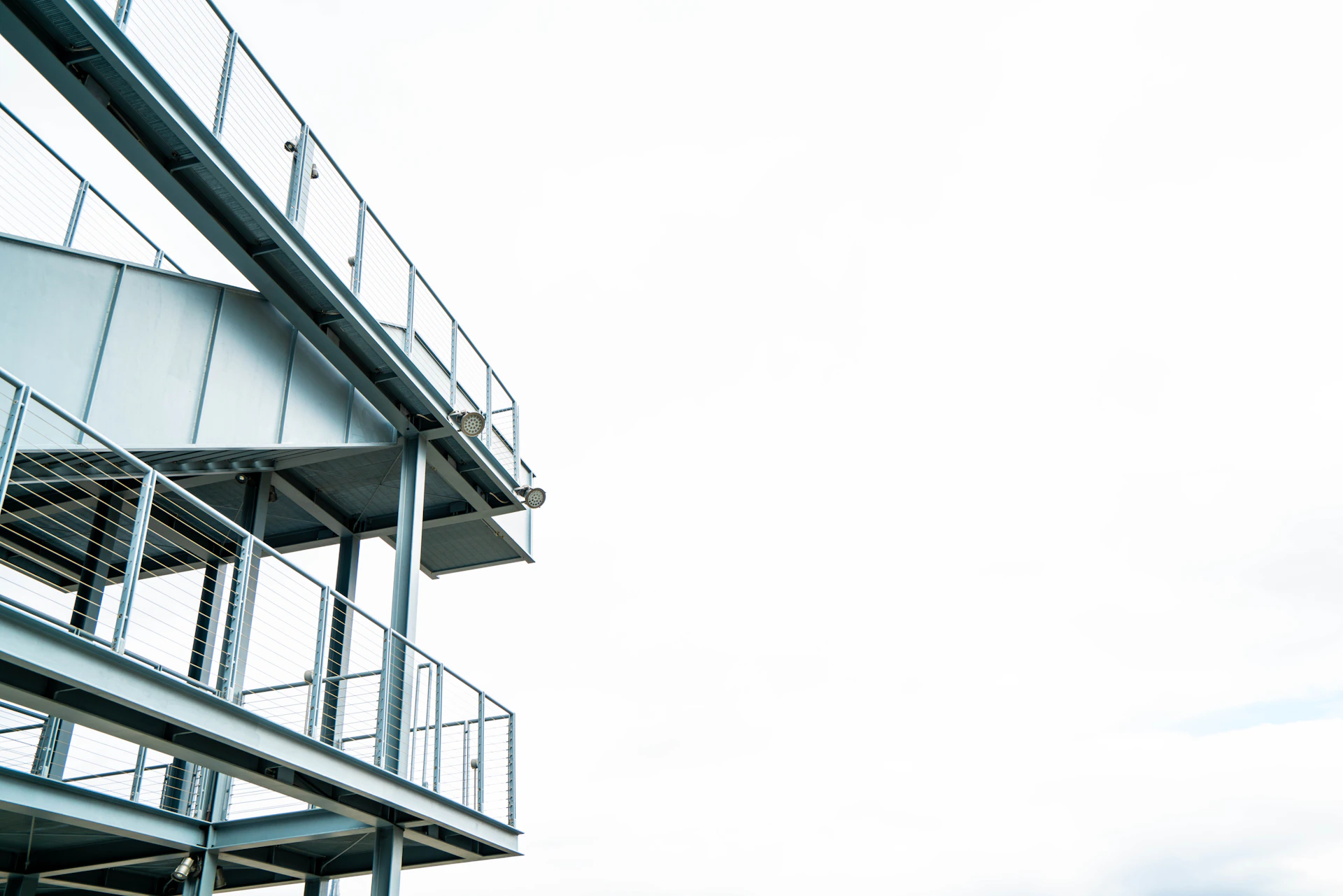 Wide-angle shot of a sleek, modern industrial facility under bright daylight, emphasizing clean lines and structural steel.
