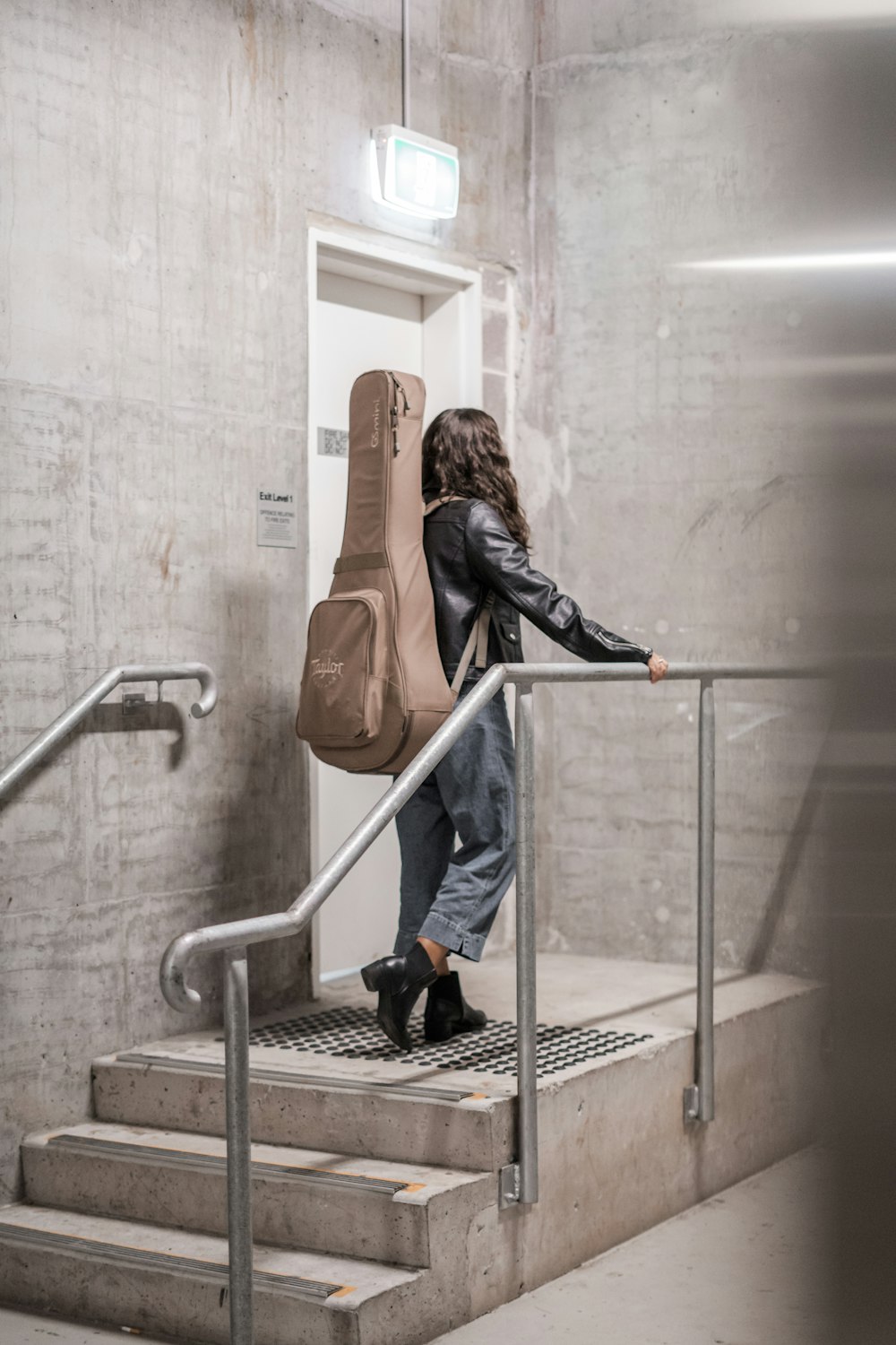 Mujer que lleva una bolsa marrón de pie cerca de la puerta cerrada