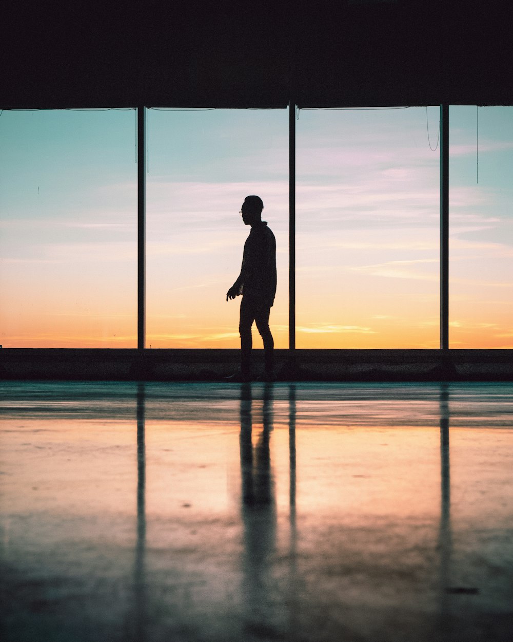 silhouette of man standing near window