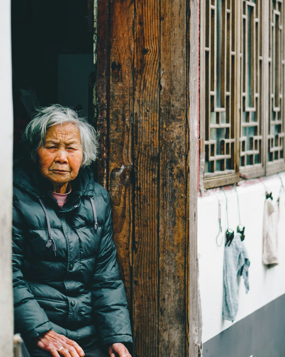 woman standing beside brown and white wall