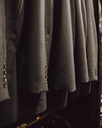 a bunch of suits hanging on a rack