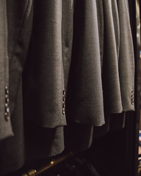 a bunch of suits hanging on a rack