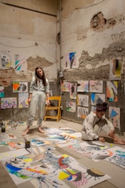 woman standing and another woman sitting on floor