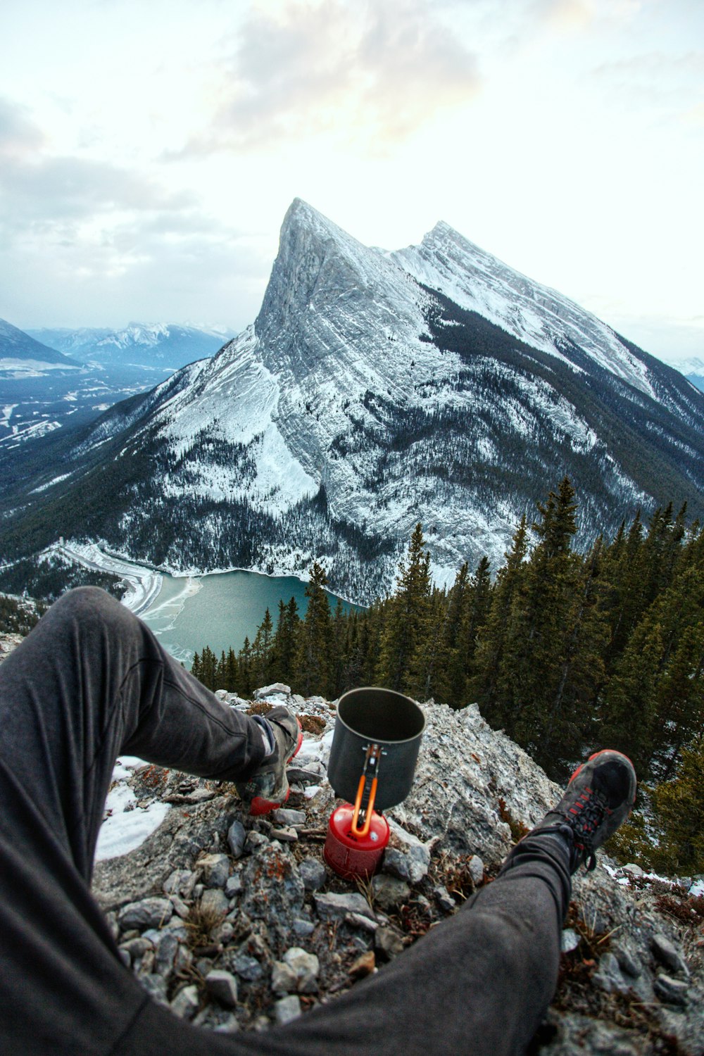 person sitting on edge of mountain during daytime