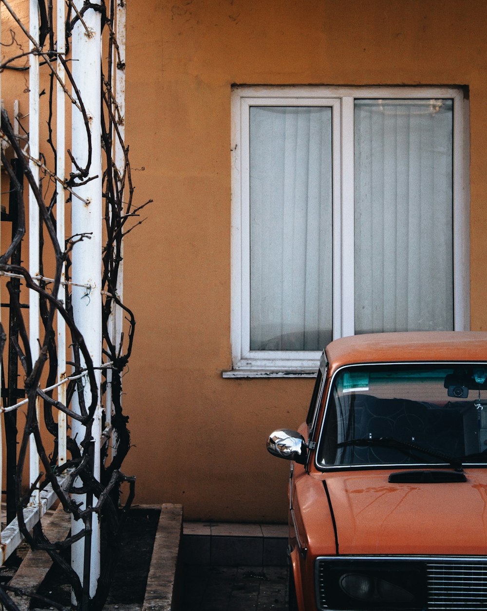 red car near window and metal gate