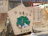 Wooden ema plaques are hanging, featuring Japanese characters and illustrations. One plaque prominently displays a drawing of a figure in traditional Japanese attire, with text written in Japanese around it.
