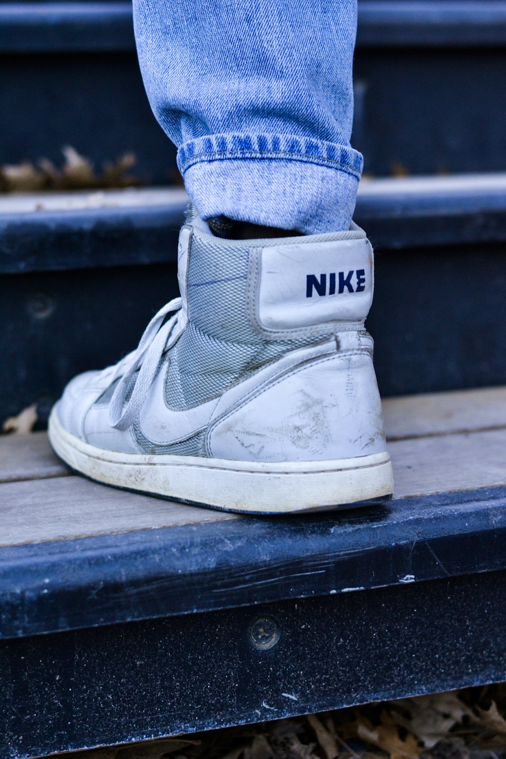 person wearing white and gray Nike sneakers